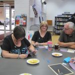 Studying the information at A Taste Of Murder - photo by Juliamaud